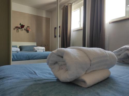 een witte handdoek bovenop een bed bij Grape's Home in Canelli
