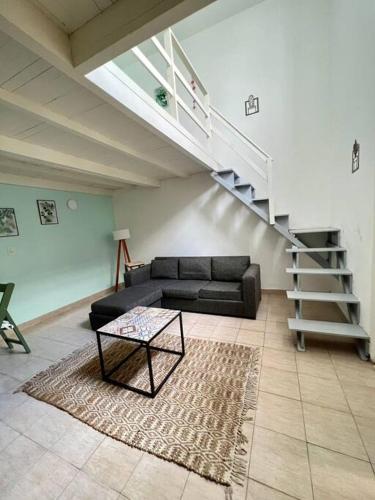 sala de estar con sofá negro y escalera en Apartamento con terraza en Buenos Aires