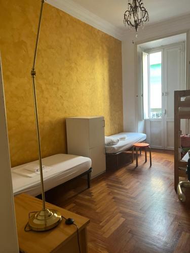 ローマにあるヴァレーゼ ゲストハウスのベッド2台とランプが備わる部屋