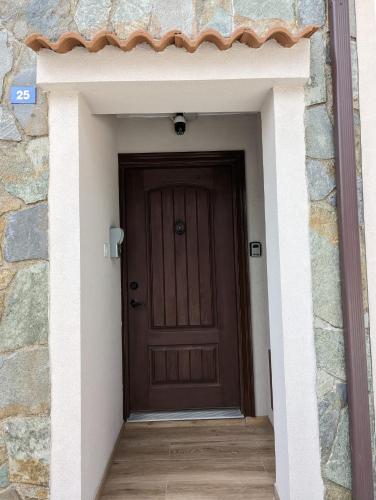 a brown door in a stone building with a wooden floor at Archontiko Adamou in Kyperounda