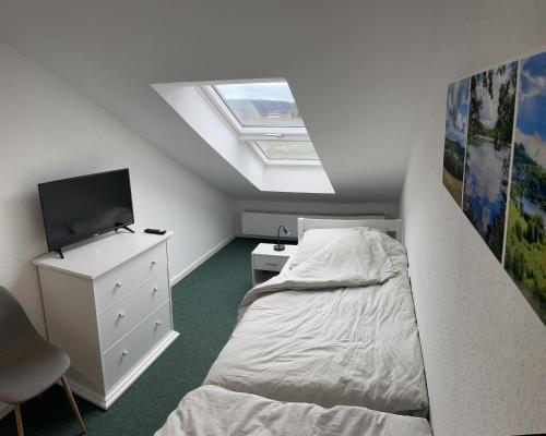 a small bedroom with a bed and a skylight at Traumhaus am Wald 2 in Daun
