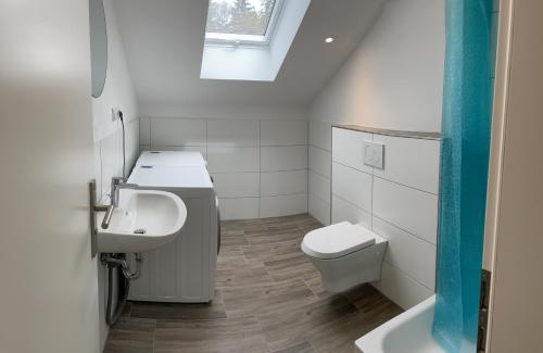 a white bathroom with a sink and a toilet at Traumhaus am Wald 2 in Daun