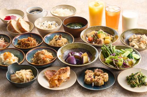une table recouverte de bols de différents types de denrées alimentaires dans l'établissement Hotel Resol Machida, à Machida