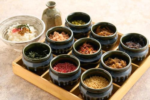 a tray of bowls of food on a table at Hotel Resol Machida in Machida
