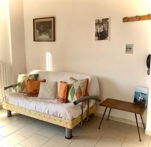 - un canapé avec des oreillers dans le salon dans l'établissement "La Casa di FRILA" Bilocali a Borgo Celano, à San Giovanni Rotondo