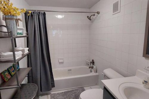 a bathroom with a tub and a toilet and a sink at Nassau Harbour Cozy 2 bedroom Condo in Nassau