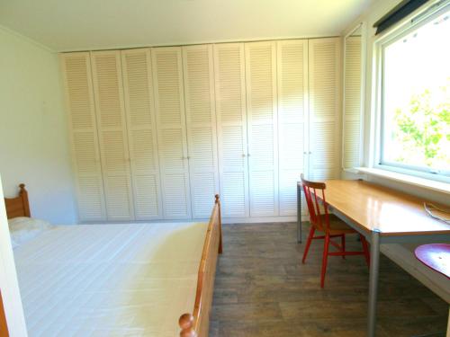 a bedroom with a bed and a desk and a window at House near the University in Ås - Ski in Ås