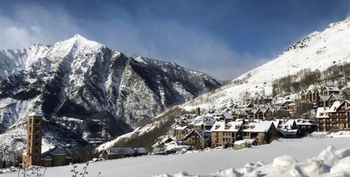 a village covered in snow with mountains in the background at Apartamento con terraza y vistas panorámicas en Taüll con plaza de parking in Taull