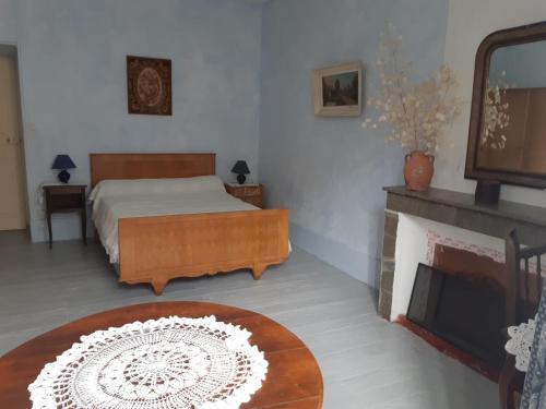 um quarto com uma cama e uma lareira em Maison de caractère- grand appartement en location em Pompidou