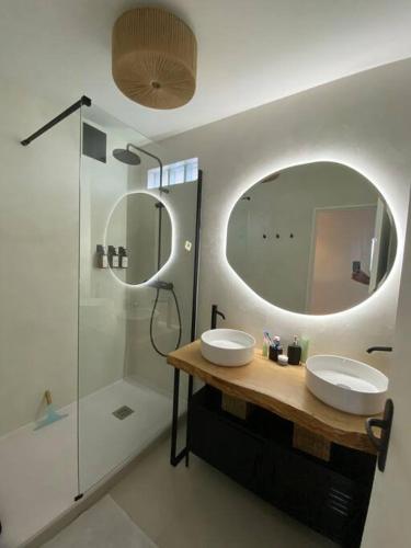 une salle de bain avec deux lavabos et un grand miroir dans l'établissement Appartement refait à neuf, à Alfortville