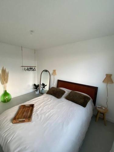 - une chambre avec un lit blanc et un plateau en bois dans l'établissement Appartement refait à neuf, à Alfortville