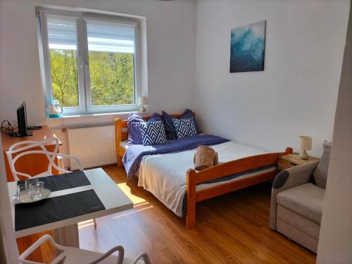 a small bedroom with a bed and a table at Pokoje i apartamenty Mak in Łeba
