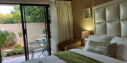 a bedroom with a bed and a view of a patio at Bhotani-on-Bax in Port Elizabeth