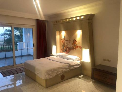 een slaapkamer met een groot bed en een groot raam bij Delta Sharm Symphony in Sharm El Sheikh