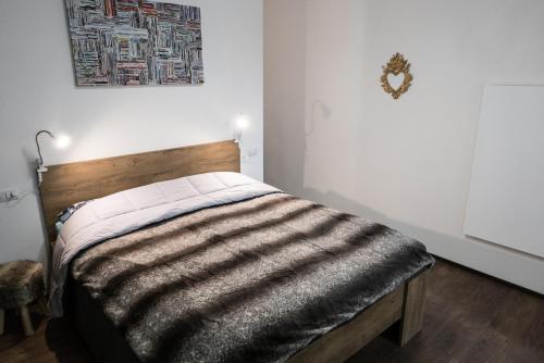 Cama en habitación blanca con cabecero de madera en Casa Nenette VDA-AOSTA- n0108 en Aosta