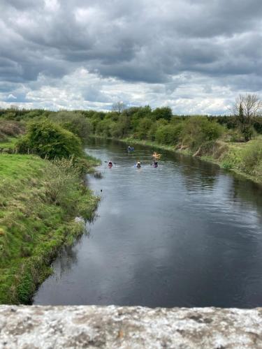 a river with people rafting in it on a cloudy day at Inny River Lodge in Rathowen