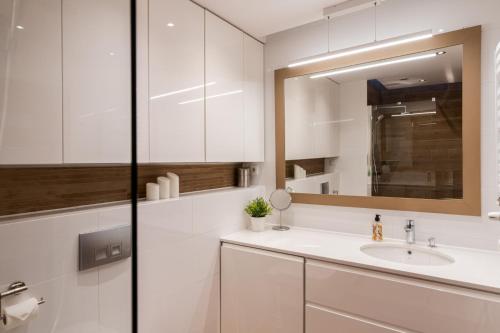 uma casa de banho branca com um lavatório e um espelho em Superior Apartment with big terrace and parking Zablocie em Cracóvia