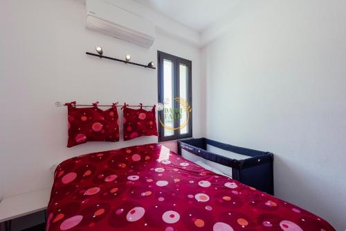 Un dormitorio con una cama roja con almohadas de lunares en Appartamento Ginny Dachi Farm, en Andora