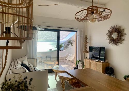 a living room with a dining room table and a view of the ocean at Front de mer 35m2 vue époustouflante in Carry-le-Rouet