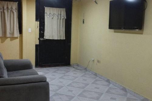 uma sala de estar com um sofá e uma televisão na parede em Casa en Joyas Cuautitlan grande y cómoda em Cuautitlán