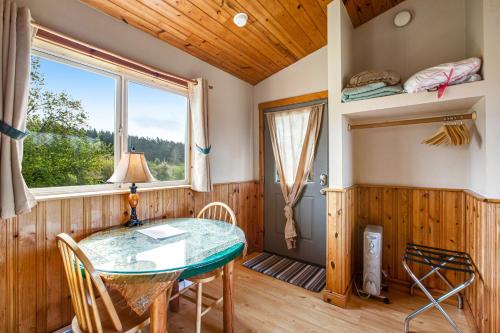 ein Esszimmer mit einem Tisch und einem Fenster in der Unterkunft Deer Harbor Cottages in Eastsound
