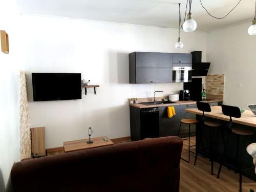 a kitchen and a living room with a counter and a kitchen at Appartement DeGaulle in Châteaurenard