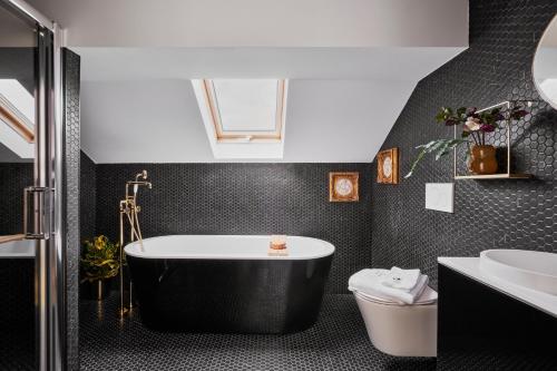 uma casa de banho preta com uma banheira e um lavatório em Halcyon Days Luxembourg no Luxemburgo