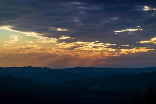 a sunset over a mountain range with clouds at Oasi di Mastarone - Il vino e le Rose in Momperone