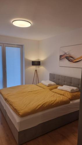 a bedroom with a large bed with a yellow blanket at komfortná novostavba v centre in Poprad