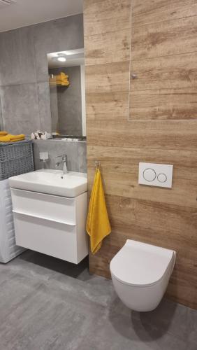 uma casa de banho com um WC branco e um lavatório. em komfortná novostavba v centre em Poprad