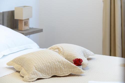 a bed with two pillows and a rose on it at Apartment Violeta 1 with private terrace in Dubrovnik