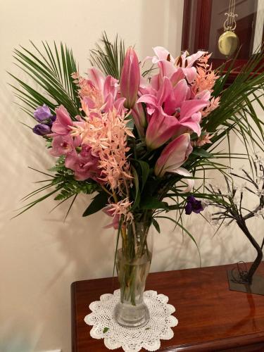 a vase filled with pink flowers on a table at Inny River Lodge in Rathowen