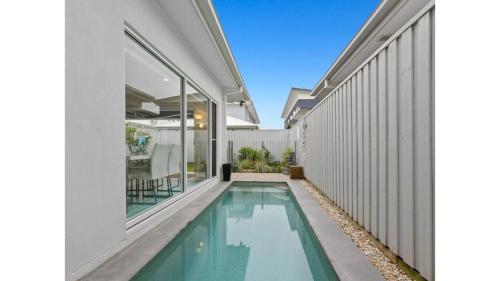 a swimming pool in the backyard of a house at Sea Poppy in Casuarina