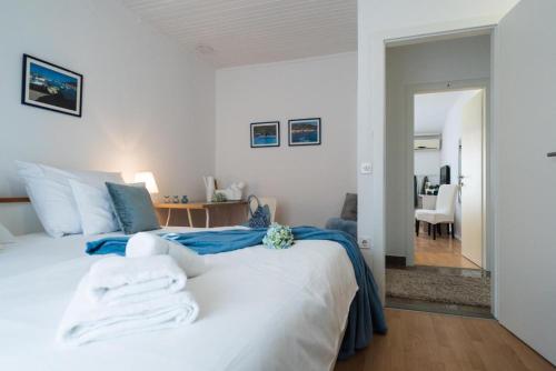 Un dormitorio con una gran cama blanca con sábanas azules. en GUEST HOUSE LANA 1, en Split