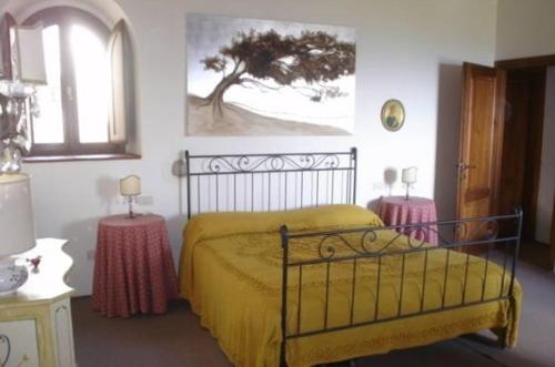 1 dormitorio con 1 cama amarilla y 2 mesas en Casa Adrigagi, en Pratolino
