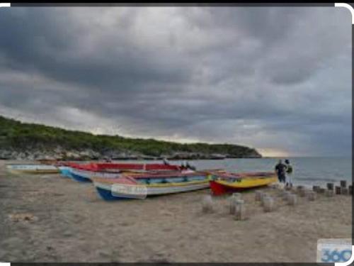 a group of boats sitting on a beach at Mango tree Oasis in Treasure Beach