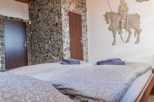 a bedroom with a bed with a horse on the wall at Penzion hrad Doubravka in Teplice