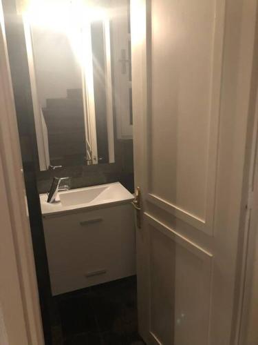 a bathroom with a sink and a door with a mirror at Spetses Cozy Villa in Spetses
