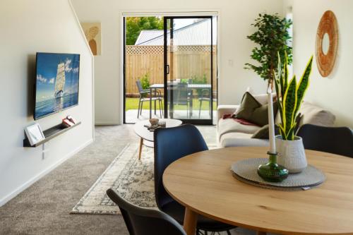 uma sala de estar com uma mesa de madeira e cadeiras em Riccarton 2 bed 1 bath w/garage em Christchurch