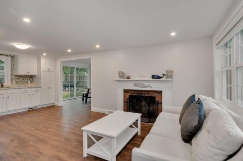 a living room with a white couch and a fireplace at Cape Cod - Dennis Beach House - Walk to the Beach in Dennis