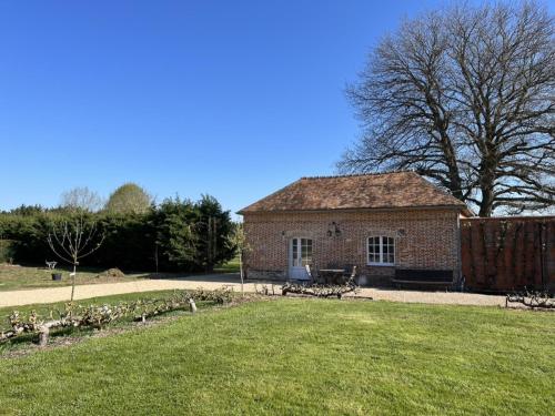 a brick building in a field with a grass yard at Chateau d' Emalleville in Émalleville
