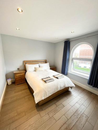 Un dormitorio con una cama grande y una ventana en Modern 1 Bedroom flat close to Vauxhall en Londres