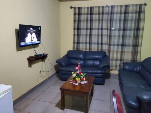 - un salon avec un canapé bleu et une table dans l'établissement RÉSIDENCE TCHAMS, à Yaoundé