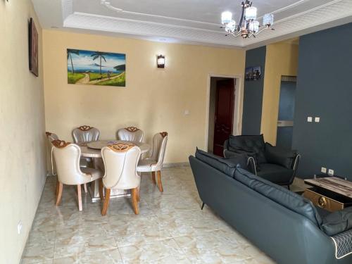 uma sala de estar com uma mesa e um sofá em Primeshare Luxury Apartments for Family Travelers with Swimming Pool, Yaounde em Iaundé