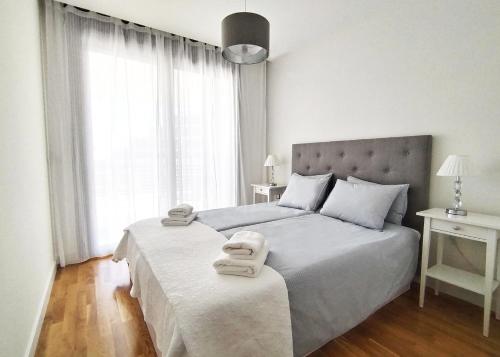une chambre avec un grand lit avec des serviettes dessus dans l'établissement Luxury Apartment Infinity View, à Arenales del Sol