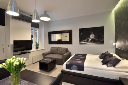a bedroom with a bed and a couch and a tv at Urban Spirit Apartment in Budapest
