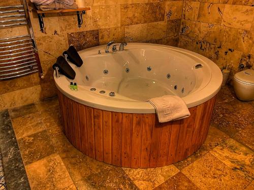 a large wooden tub in a bathroom with a toilet at Rose Valley Hotel in Goreme