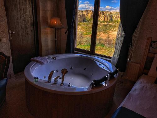 a bath tub in a room with a view of the canyon at Rose Valley Hotel in Goreme