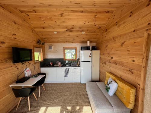 a kitchen with a refrigerator and a table in a cabin at Laurels Retreat in Mangonui