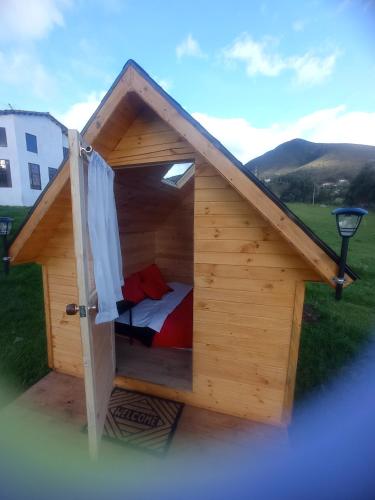 a small wooden dog house with a bed in it at Hospedaje Guatavita cabaña tippie in Guatavita